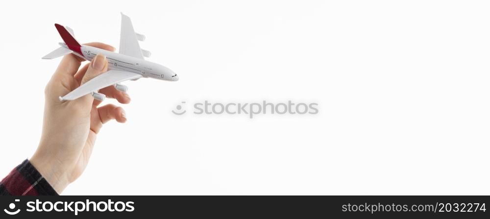 front view hand holding airplane figurine with copy space