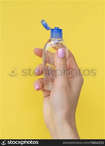 front view hand holding plastic bottle with hand sanitizer. High resolution photo. front view hand holding plastic bottle with hand sanitizer. High quality photo