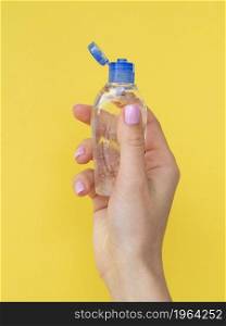 front view hand holding plastic bottle with hand sanitizer. High resolution photo. front view hand holding plastic bottle with hand sanitizer. High quality photo