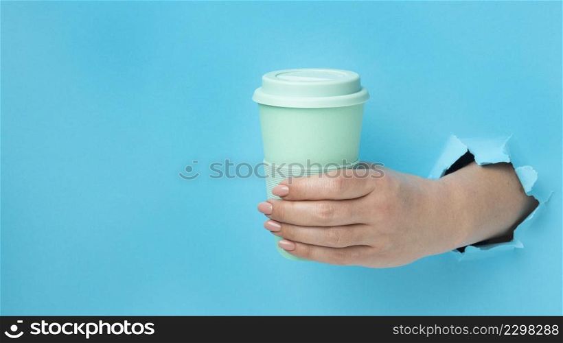 front view hand holding reusable cup with copy space