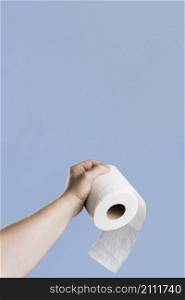 front view hand holding toilet paper with copy space