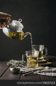 front view hand pouring tea glass with teapot. Beautiful photo. front view hand pouring tea glass with teapot