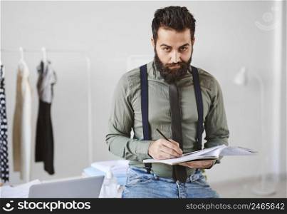 front view handsome male fashion designer atelier with papers