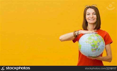 front view happy woman holding globe with copy space