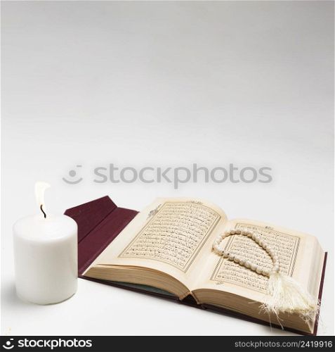 front view holy book with lit candle