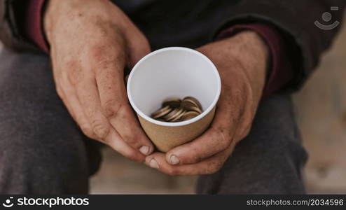 front view homeless man holding cup with coins