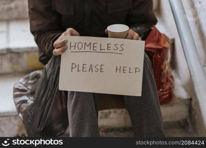 front view homeless man holding help sign plastic bag