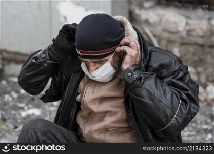 front view homeless man outdoors putting medical mask