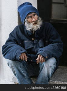 front view homeless man with beard doorstep