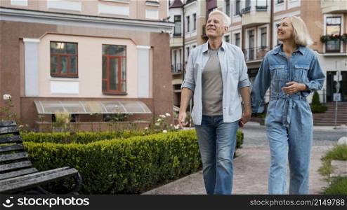 front view if older couple holding hands city