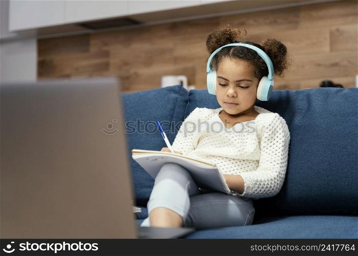 front view little girl during online school with laptop headphones