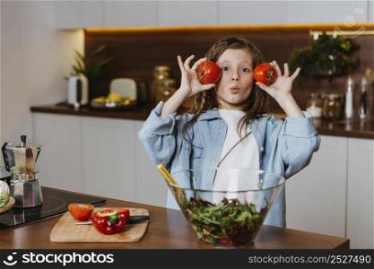 front view little girl kitchen having fun with vegetables