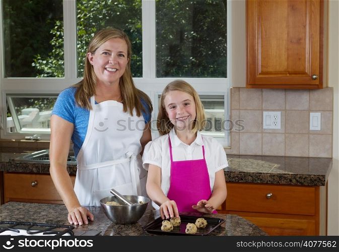 Front view, looking forward, of mother and her young daughter preparing to make cookies