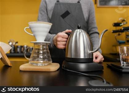 front view male barista holding kettle