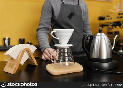 front view male barista with coffee filter kettle counter