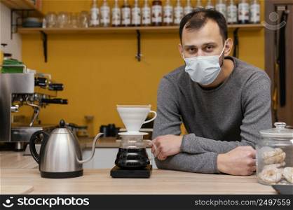 front view male barista with medical mask posing coffee shop