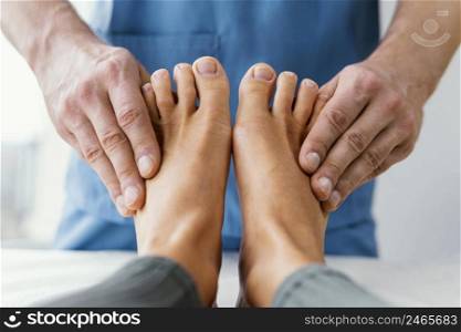 front view male osteopathic therapist checking female patient s toes