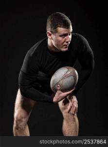 front view male rugby player holding ball with one hand