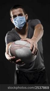 front view male rugby player with medical mask holding ball