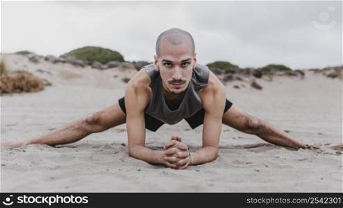 front view man beach exercising yoga positions sand