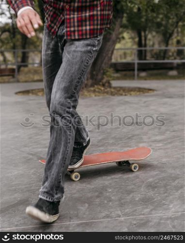 front view man doing tricks with skateboard outside park