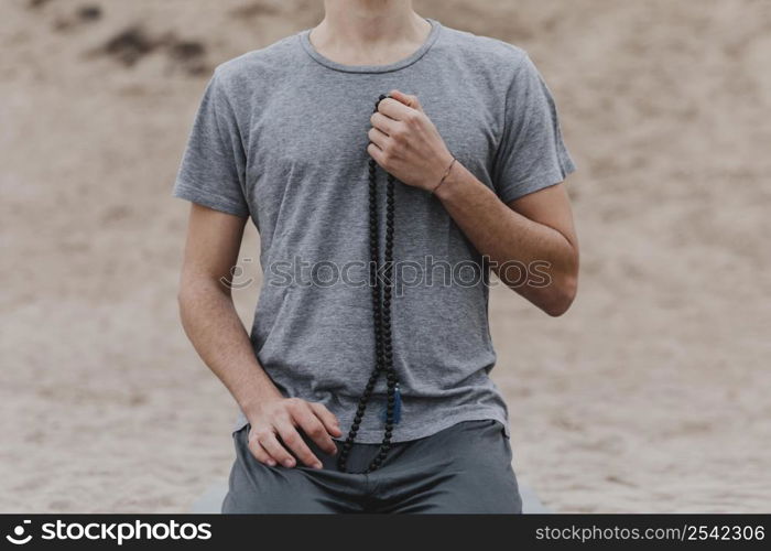 front view man holding rosary outdoors