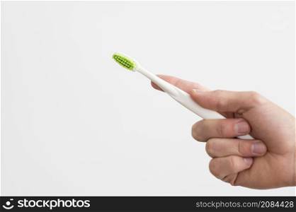 front view man holding toothbrush with copy space