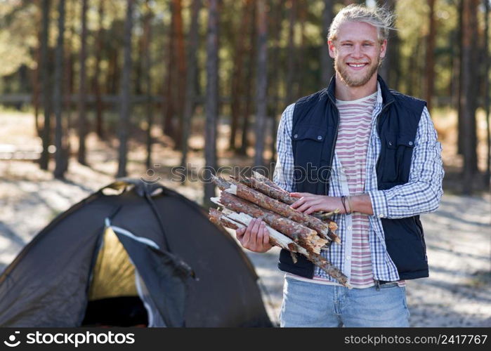 front view man holding wood fire