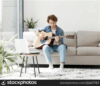 front view man learning guitar online