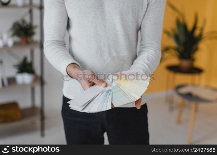 front view man planning redecorate house using paint palette