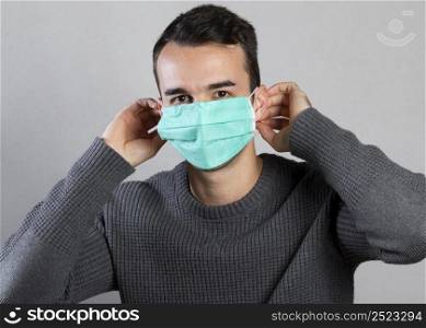 front view man putting medical mask face