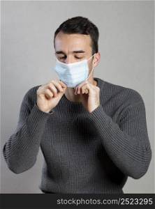 front view man putting medical mask prevention