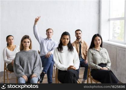 front view man raising hand question group therapy session