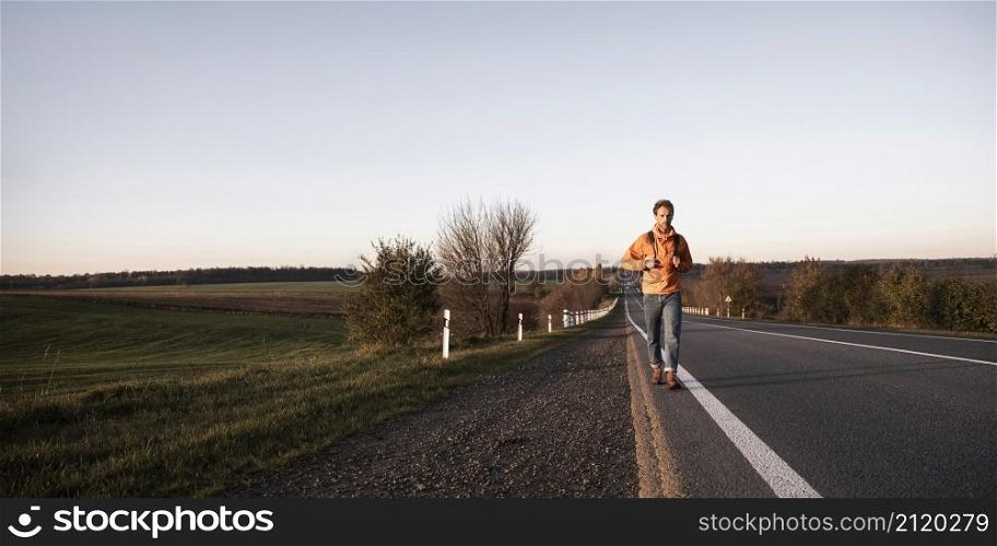 front view man walking road alone