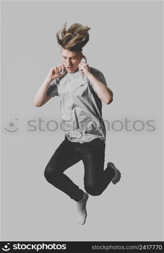 front view man with headphones jumping air