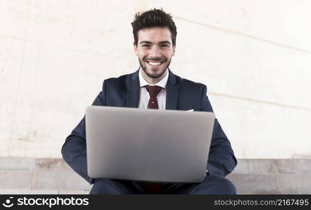 front view man with laptop looking camera