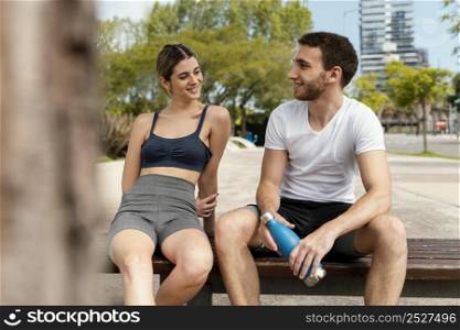 front view man woman resting outdoors after exercising