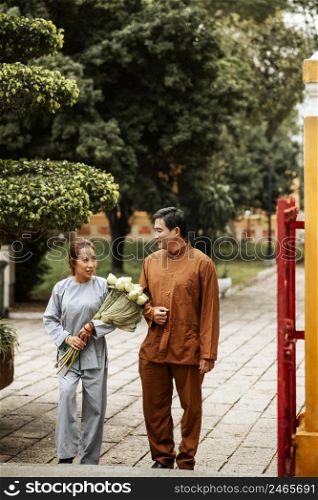 front view man woman temple with incense bouquet flowers