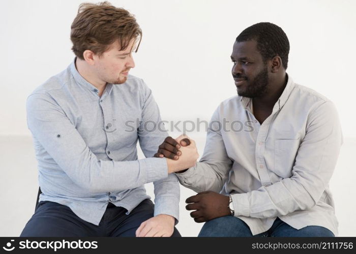 front view men holding hands consoling each other