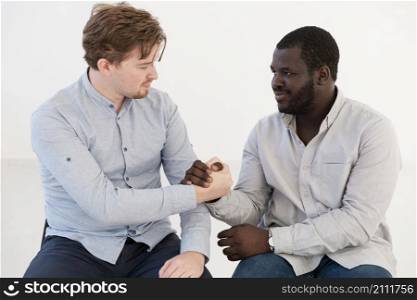 front view men holding hands consoling each other