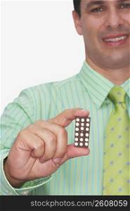 Front view of a businessman holding a domino and smiling