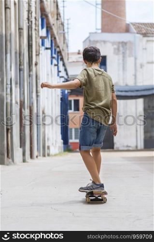 Front view of a cheerful skater boy riding on the city in a sunny day