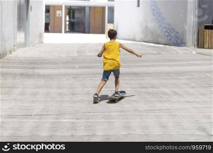 Front view of a cheerful skater boy riding on the city in a sunny day