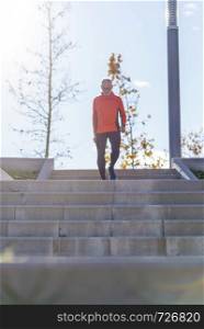 Front view of a senior caucasian athlete man training running up and down the stairs outdoors in a park in a sunny day