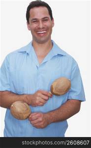 Front view of a young man holding a pair of maracas