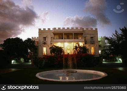 Front view of an illuminated bungalow with a fountain in the foreground, Barbados