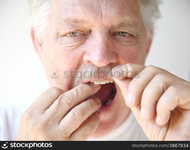 front view of an older man practicing good dental hygiene