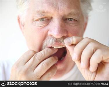 front view of an older man practicing good dental hygiene