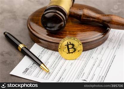 Front view of Bitcoin cryptocurrency in ront of gavel with pen.Tax paying concept.