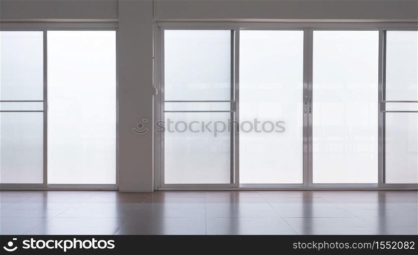 Front view of frosted glass sliding doors with screen doors and light reflection on tile floor surface in empty room